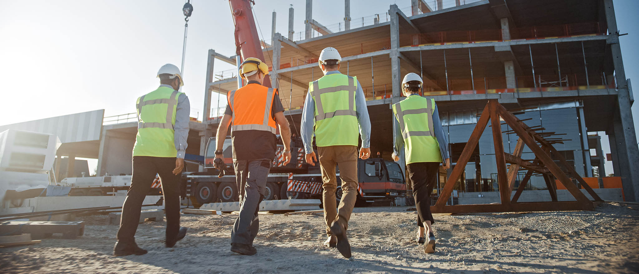 Four workers walking on a property development site